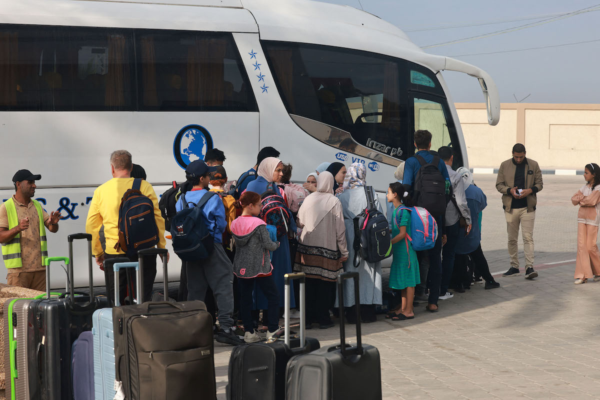 People wait on the Palestinian side of the Rafah border crossing with Egypt in the southern Gaza Strip. (File/AFP)