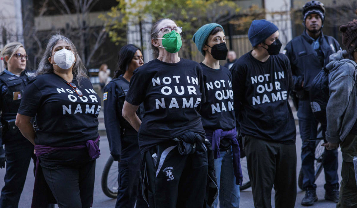 Arrested protesters chant as they await to board the transport outside the Accenture Tower in Chicago, Monday, Nov. 13, 2023. (AP)