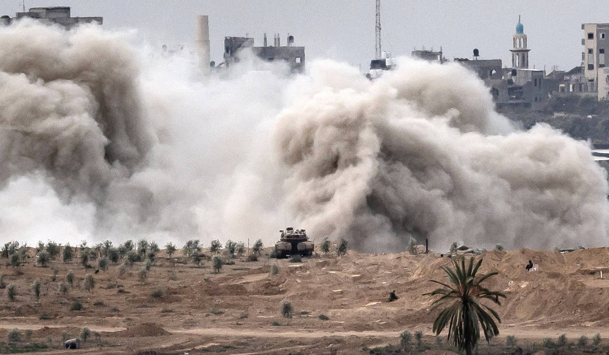 This picture taken on November 12, 2023 from a position along the border with the Gaza Strip in southern Israel shows an Israeli tank and a plume erupting during Israeli bombardment on the Palestinian enclave amid ongoing battles. (AFP)