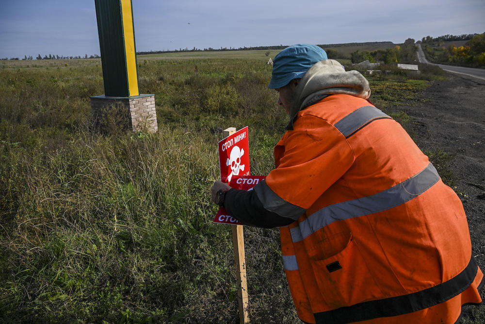 Extensive deployment by Russia in Ukraine drove a global rise of new casualties from the weapons last year. Above, a Ukrainian mine-clearing personnel places signs indicating the presence of mines along a roadside near Izyum, eastern Ukraine on Oct. 1, 2022. (AFP)