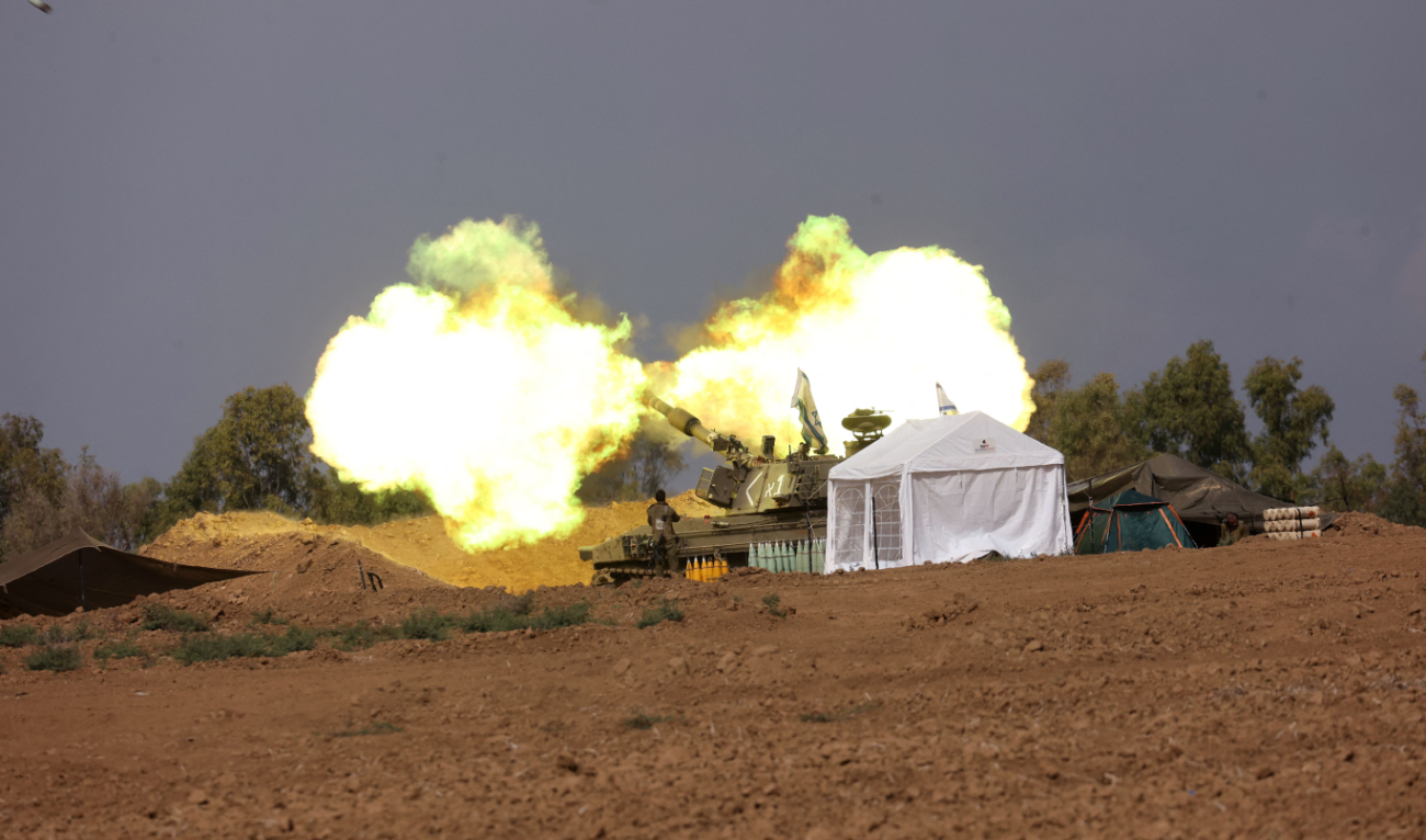 An Israeli artillery crew fires a shell toward Gaza from a field near the border on Tuesday. (AFP)