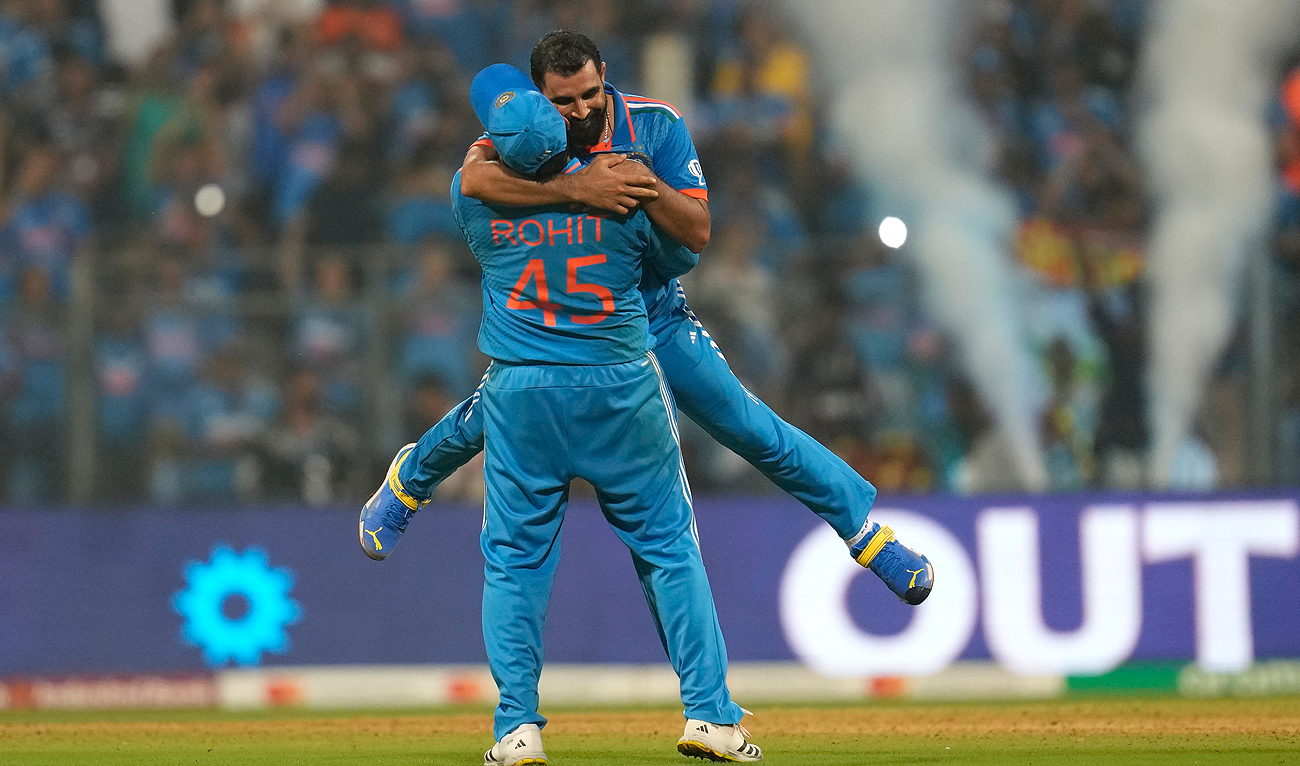 India's captain Rohit Sharma lifts Mohammed Shami after he took the last wicket and overall seven wickets to beat New Zealand by 70 runs during the ICC Men's Cricket World Cup first semifinal match in Mumbai, India, Wednesday, Nov. 15, 2023. (AP)