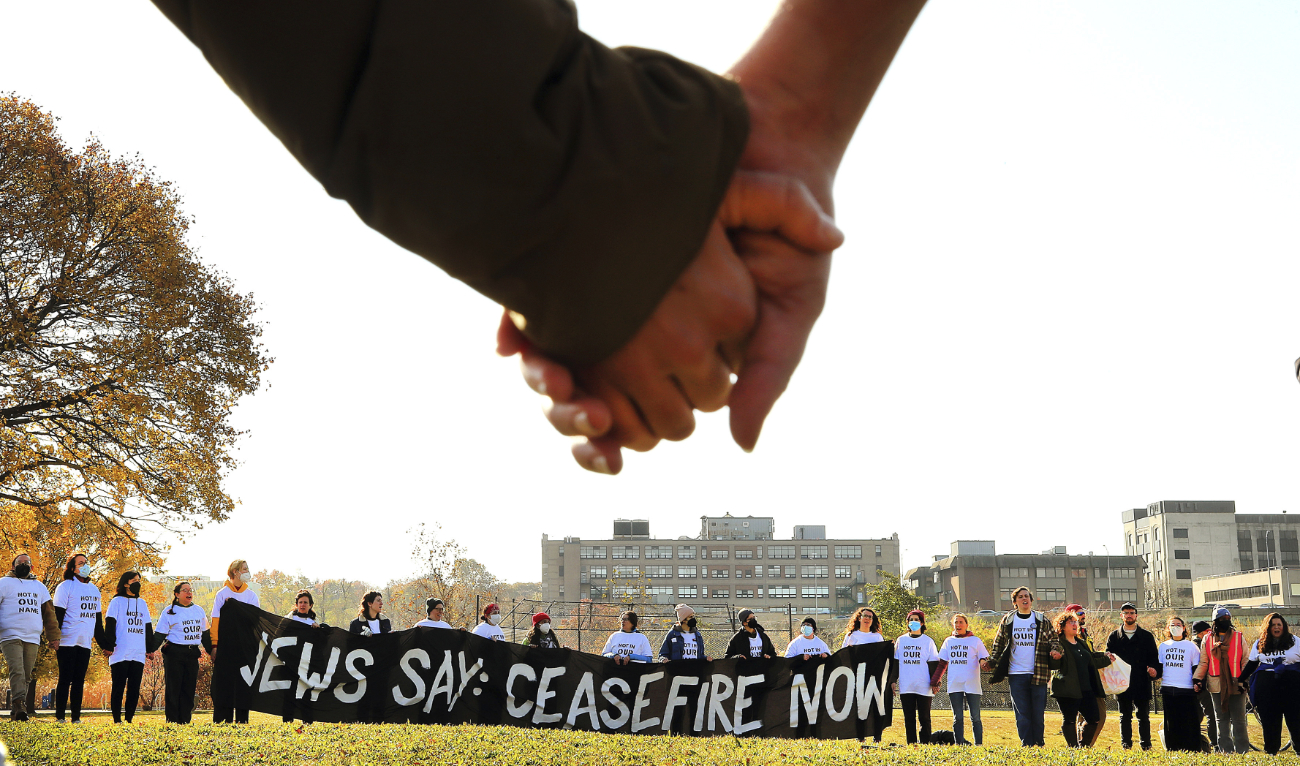 Demonstrators calling for a ceasefire in the Gaza Strip join hands on the field at Magazine Beach after blocking traffic on the nearby BU Bridge for several hours Thursday, Nov. 16, 2023 in Cambridge, Mass. (AP)