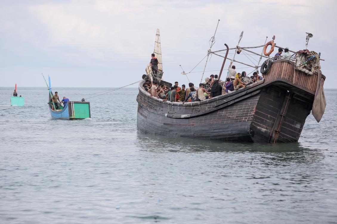A boat with Rohingya refugees is towed offshore after the nearby community gave them water and food but did not allow them to land on the beach in Pineung, Aceh province on Nov 16, 2023. (AFP)