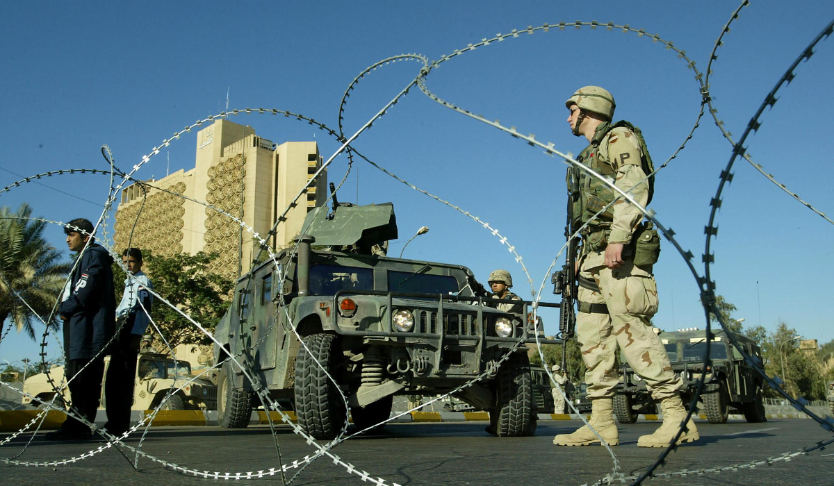 In this file photo taken on November 21, 2003 US soldiers and members of Iraqi police (L) secure the perimeter of the Palestine (background) and the Sheraton hotels in Baghdad. (AFP)