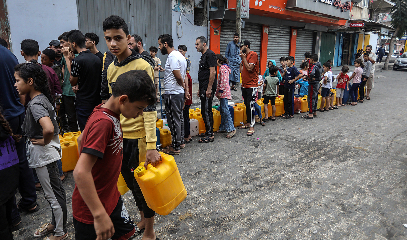 Palestinians, including children, waiting to get clean water from mobile tanks as the Israeli attacks continue in Rafah, Gaza on November 13, 2023. (Reuters)