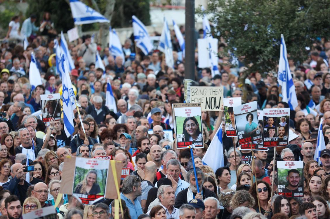 Israelis hold the Israeli flag, placards and images of hostages held in the Gaza Strip since the October 7 attack by Hamas militants in southern Israel, during a protest calling for their release outside the Prime Minister’s office in Jerusalem on Nov. 18, 2023. (AFP)