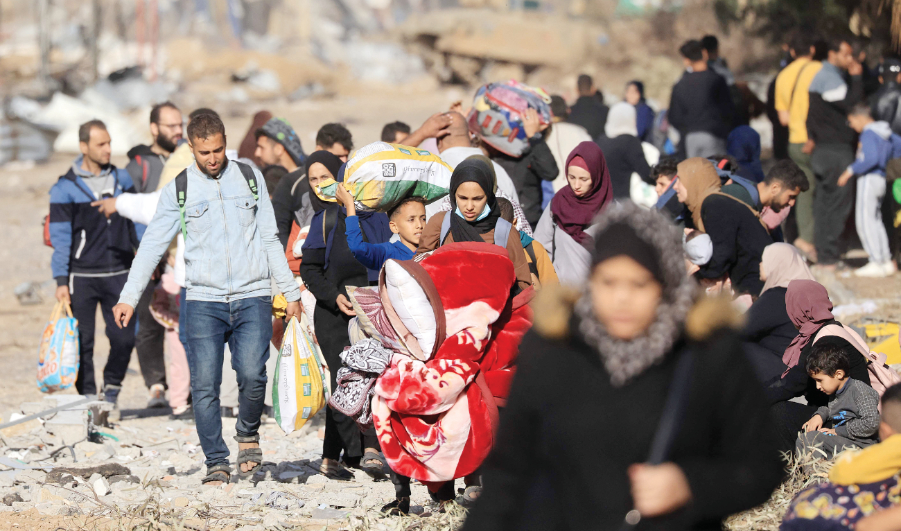 Palestinians fleeing the fighting in war-torn Gaza walk on Salaheddine Road in the Zeitoun district of the southern part of the Gaza Strip on Sunday among battles between Israel and Hamas. (AFP)
