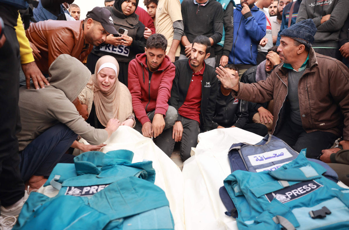 Relatives and colleagues of two Palestinian journalists Hasouna Slim and Sari Mansoor, killed in an Israeli strike, mourn over their bodies during their funeral in Deir al-Balah in the southern Gaza Strip on November 19, 2023. (AFP)
