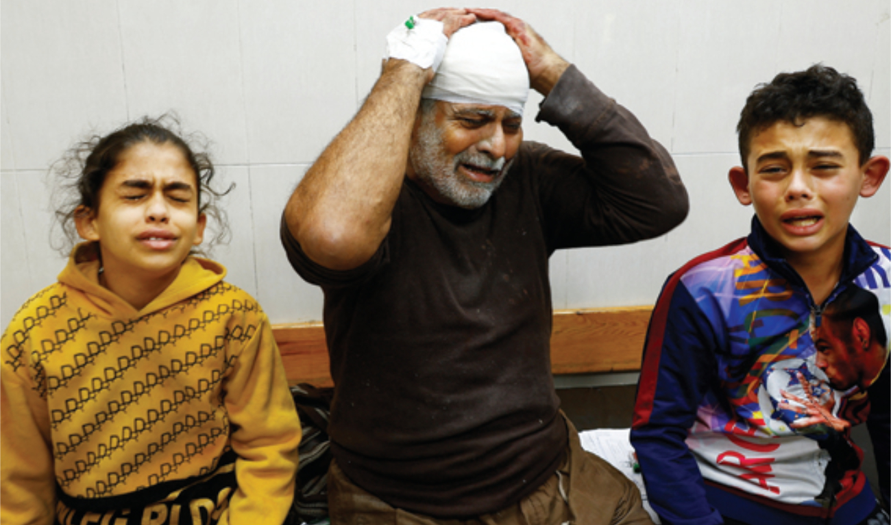 A Palestinian man wounded in an Israeli strike reacts next to children at Nasser Hospital in Khan Younis on Monday. (Reuters)