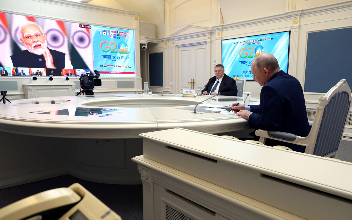 Russian President Vladimir Putin and Deputy Prime Minister Alexei Overchuk attend the G20 virtual summit, as Indian Prime Minister Narendra Modi is seen on a screen, during a video link in Moscow on Nov. 22, 2023. (Reuters)