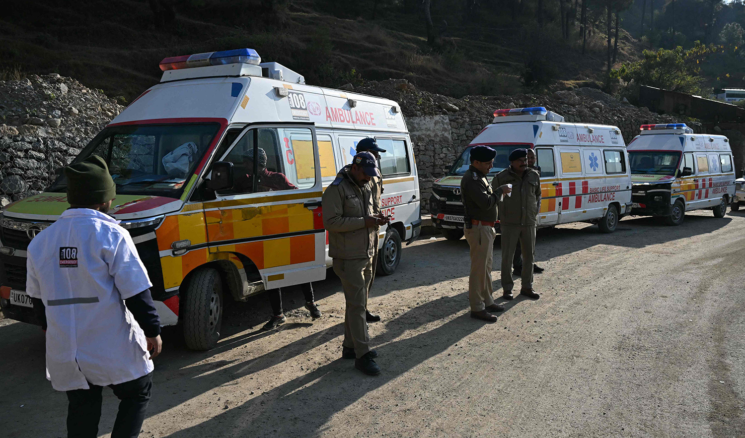 Sercurity personnel stand near ambulances on standby as rescue operation enters its final phase, to free workers trapped in the Silkyara under construction road tunnel, days after it collapsed in the Uttarkashi district of India's Uttarakhand state on November 23, 2023. (AFP)
