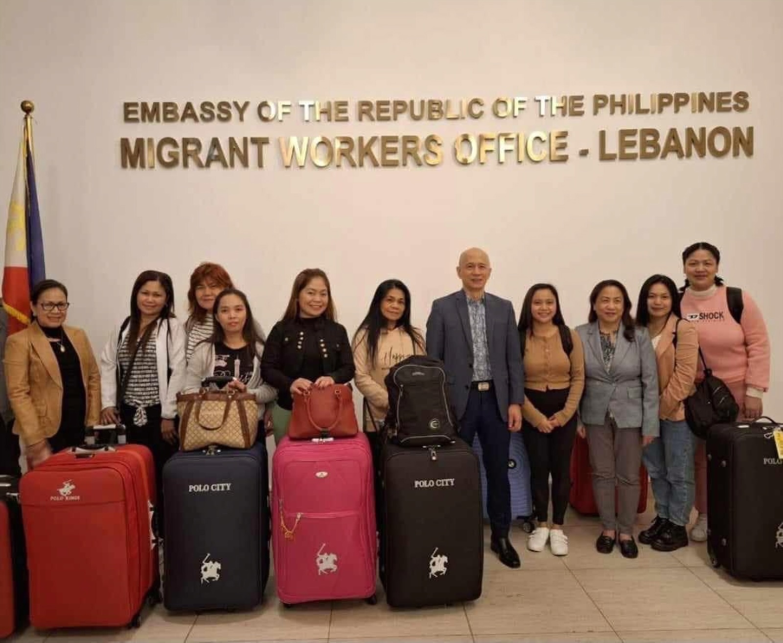 Philippine Department of Migrant Workers officers pose with eight overseas Filipino workers in Beirut, Lebanon, before their flight to Manila on Nov. 22, 2023. (DMW)