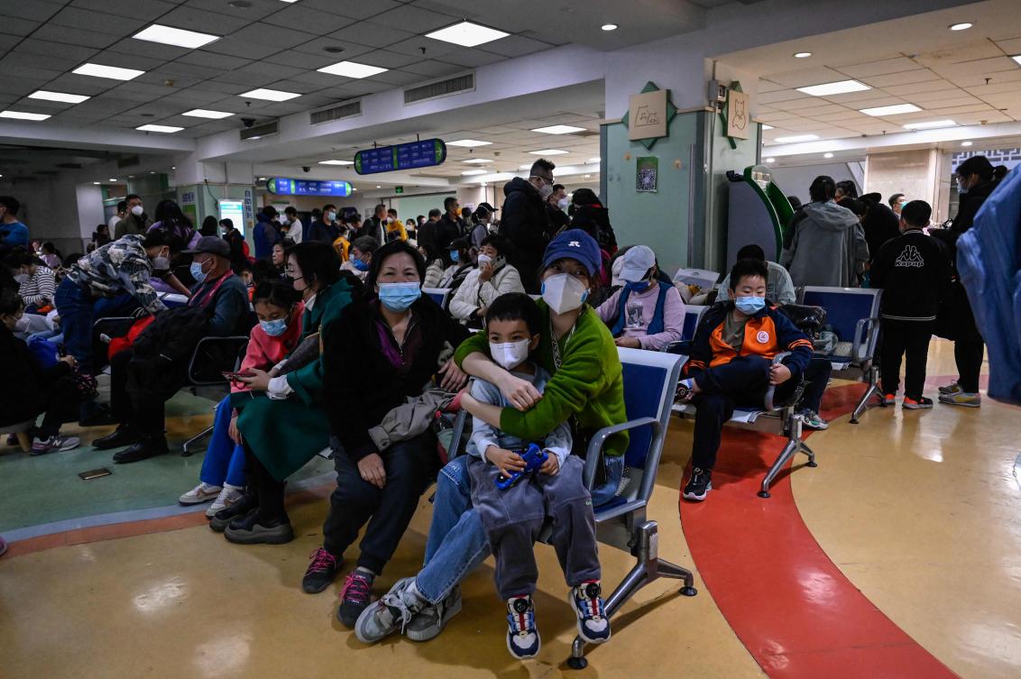 TOPSHOT - Children and their parents wait at an outpatient area at a children hospital in Beijing. China has reported an increase in "influenza-like illness" since mid-October when compared to the same period in the previous three years, the WHO said. (AFP)