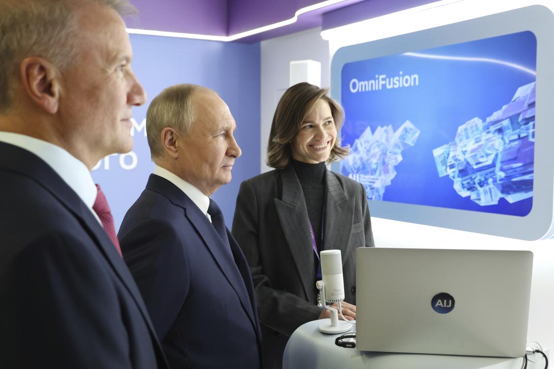 Russian President Vladimir Putin, center, and Sberbank CEO German Gref, left, visit an exhibition on artificial intelligence in Moscow on Nov. 24, 2023. (AP)