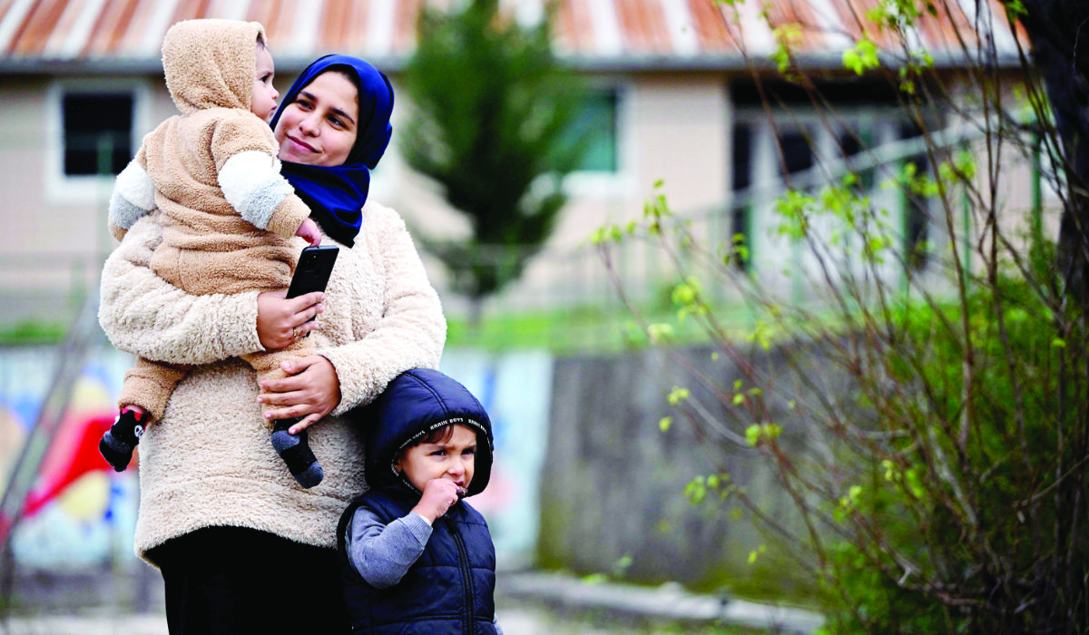 A Palestinian refugee walks with her children at a refugee center, in Salakovac, Bosnia, on Thursday. They are among 37 people who have arrived in Bosnia from Gaza in recent days. (AFP)