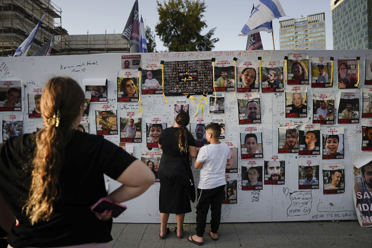 People look at photographs of hostages, mostly Israeli civilians who were abducted during the Oct. 7 Hamas attack on Israel Israel, in Tel Aviv, Israel, on Friday, Nov. 24, 2023. (AP)