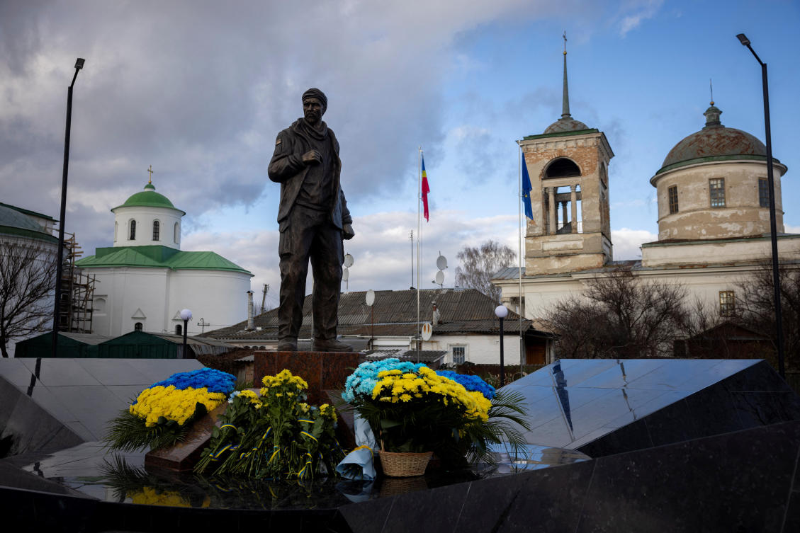 Flowers lie next to the statue of Ukrainian serviceman Oleksandr Matsievskyi, who was executed by Russian troops in 2022, after its opening in Nizhyn on Nov. 25, 2023. (Reuters)