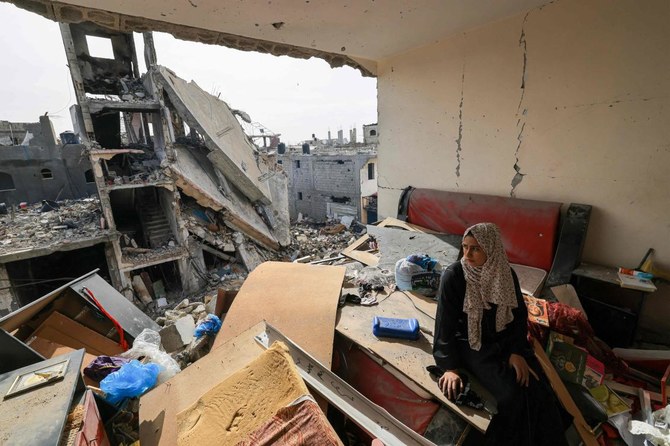 A Palestinian woman sits on debris in her damaged apartment in the Khezaa district on the outskirts of the southern Gaza Strip city of Khan Yunis, following weeks of Israeli bombardment, as a truce between Israel and Hamas entered its second day on November 25, 2023. (AFP)