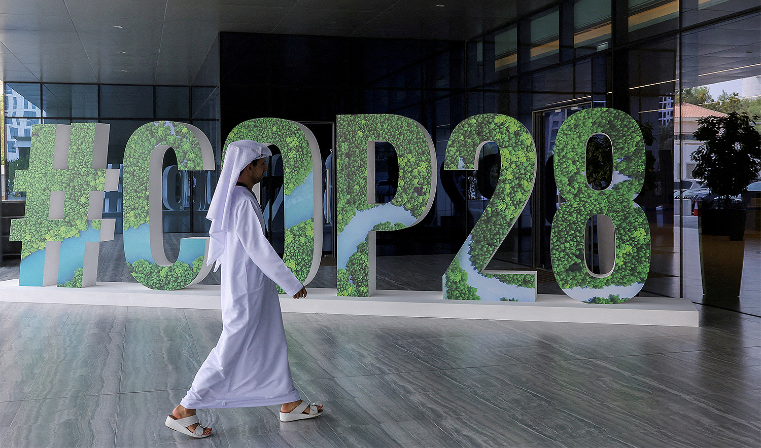 A person walks past a "#COP28" sign during The Changemaker Majlis, a one-day CEO-level thought leadership workshop focused on climate action, in Abu Dhabi, United Arab Emirates, on October 1, 2023. (REUTERS/File)