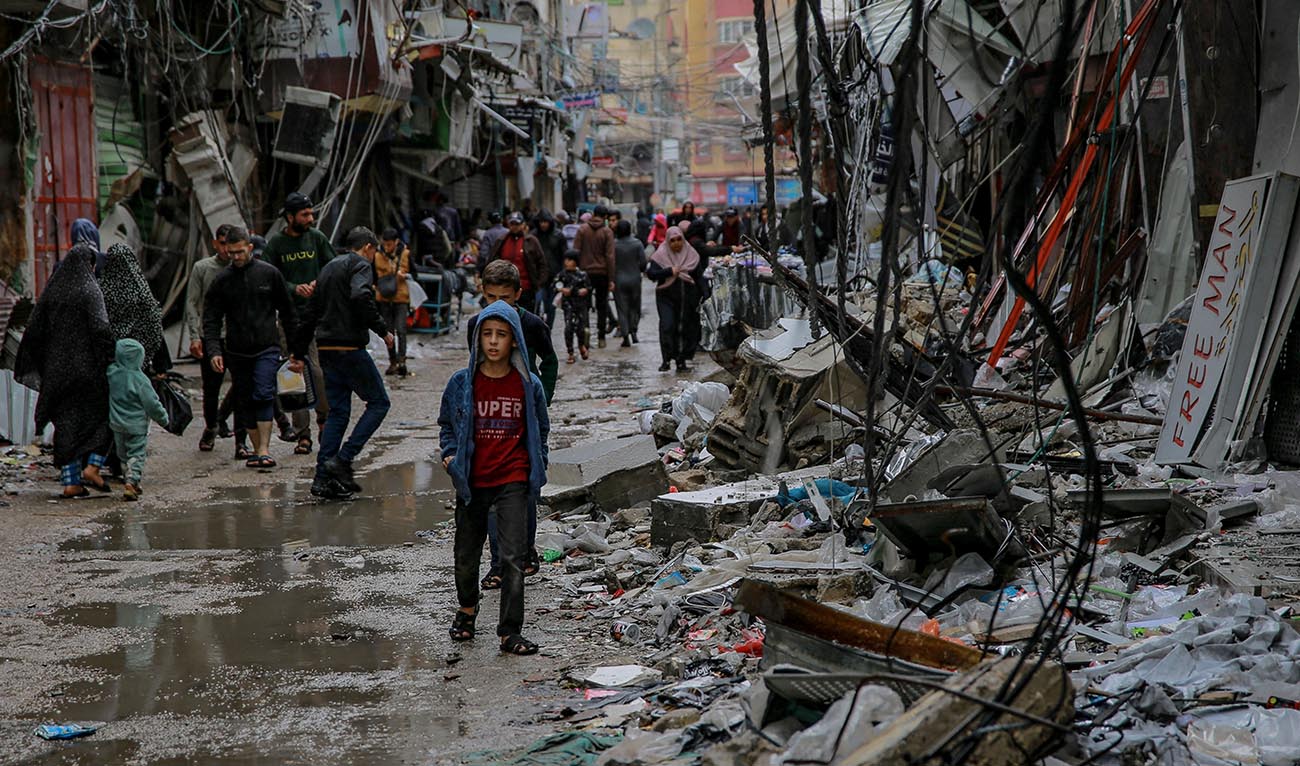 Palestinians walk amid debris of buildings hit in Israeli strikes, near Al-Zawiya market in Gaza City on November 27, 2023, on the fourth day of a truce in fighting between Israel and Hamas. (AFP)