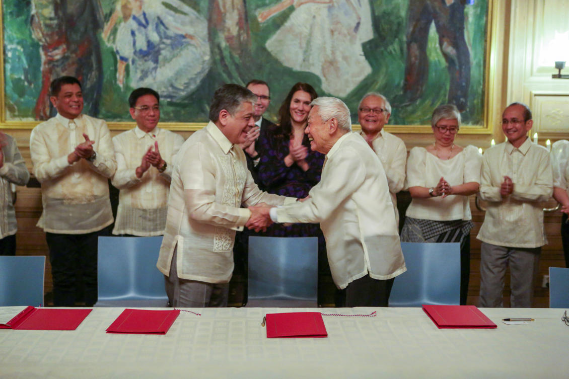 Special adviser to the President Antonio Lagdameo, center, and Luis Jalandoni of the National Democratic Front shake hands after signing their joint vision for peace in Oslo on Nov. 23, 2023. (Norwegian Ministry of Foreign Affairs via NTB)