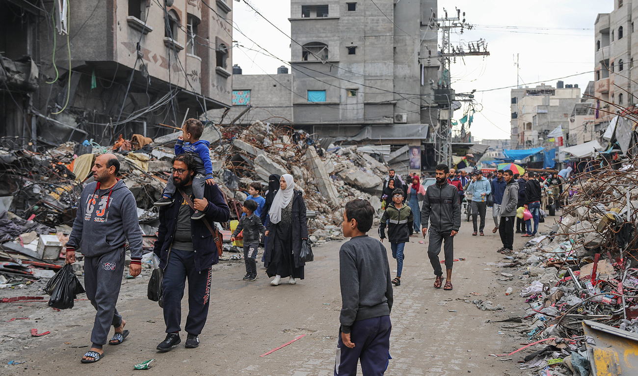 Palestinians walk on the rubble of destroyed buildings in Jebaliya refugee camp, Gaza Strip, Tuesday, Nov. 28, 2023, on the fifth day of the temporary ceasefire between Hamas and Israel. (AP)
