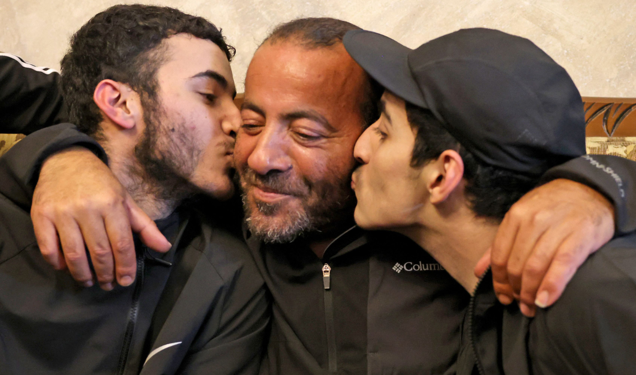 Qassam, left, and Nasrallah reunite with their father Iyad Al-Awar after both were released from an Israeli prison as part of a hostage deal between Israel and Hamas, at their home in East Jerusalem. (AFP)