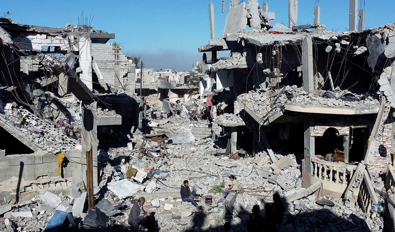 Palestinians cook among the houses destroyed in Israeli strikes during the conflict, amid the temporary truce between Israel and the Palestinian Islamist group Hamas, at Khan Younis refugee camp, in the southern Gaza Strip on November 29, 2023. (REUTERS)