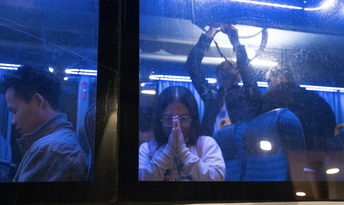 Thai nationals gesture from a bus as they leave the Shamir Hospital in Ramle, Israel, Wednesday, Nov. 29, 2023, on their way back to Thailand, after being released from Hamas custody. (AP)