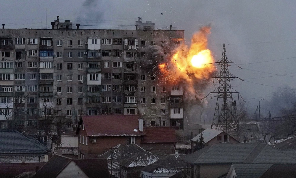 An explosion hits an apartment building after a Russian army tank fired on it in Mariupol, Ukraine. (AFP)