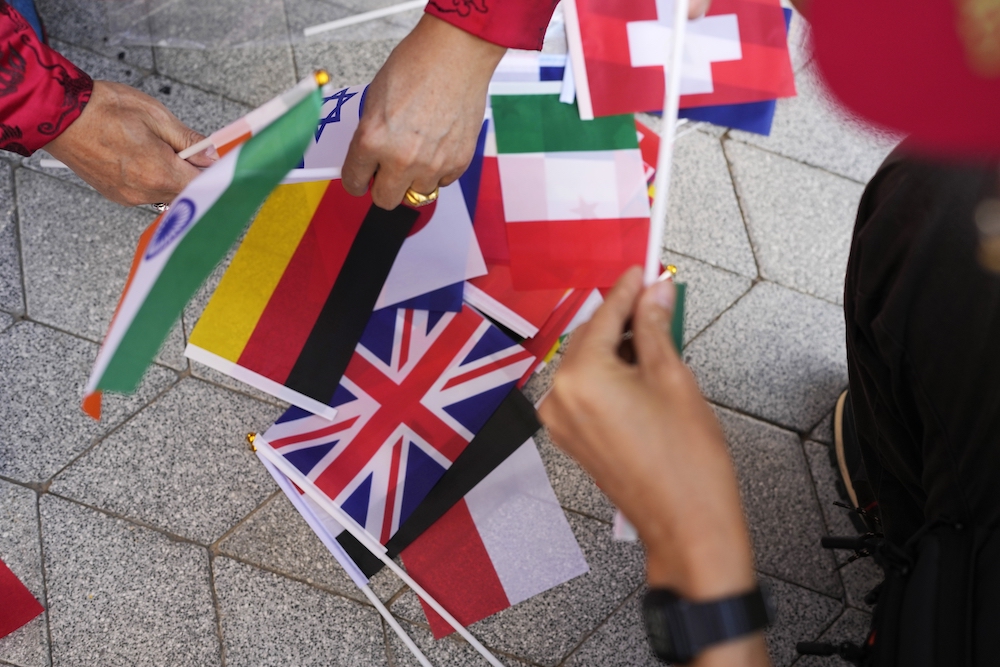 A worker adjusts flags at the COP28 UN Climate Summit on Nov. 30, 2023 in Dubai. (AP)