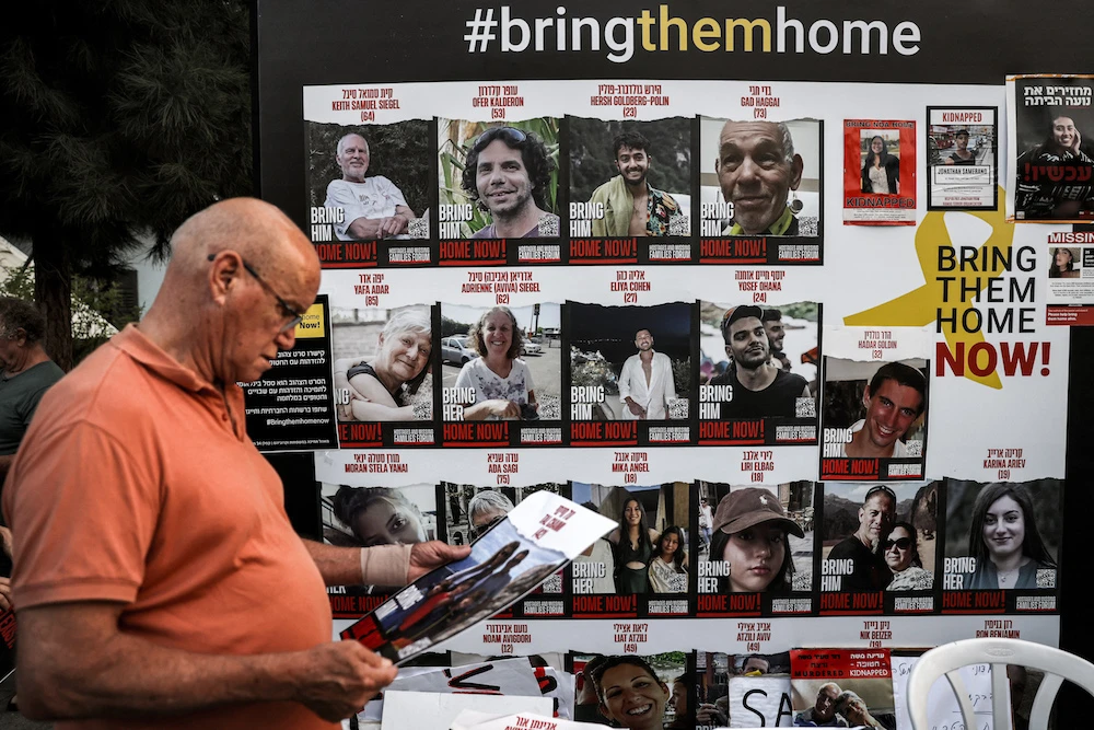  man stands by a wall identifying hostages held by Palestinian militants since the October 7 attack, during a demonstration calling for their release in Tel Aviv on October 28, 2023, amid the ongoing battles between Israel and the Palestinian group Hamas. (AFP)