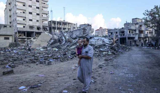 A Palestinian man walks amid the rubble of buildings destroyed during Israeli air strikes in Gaza. (AFP)