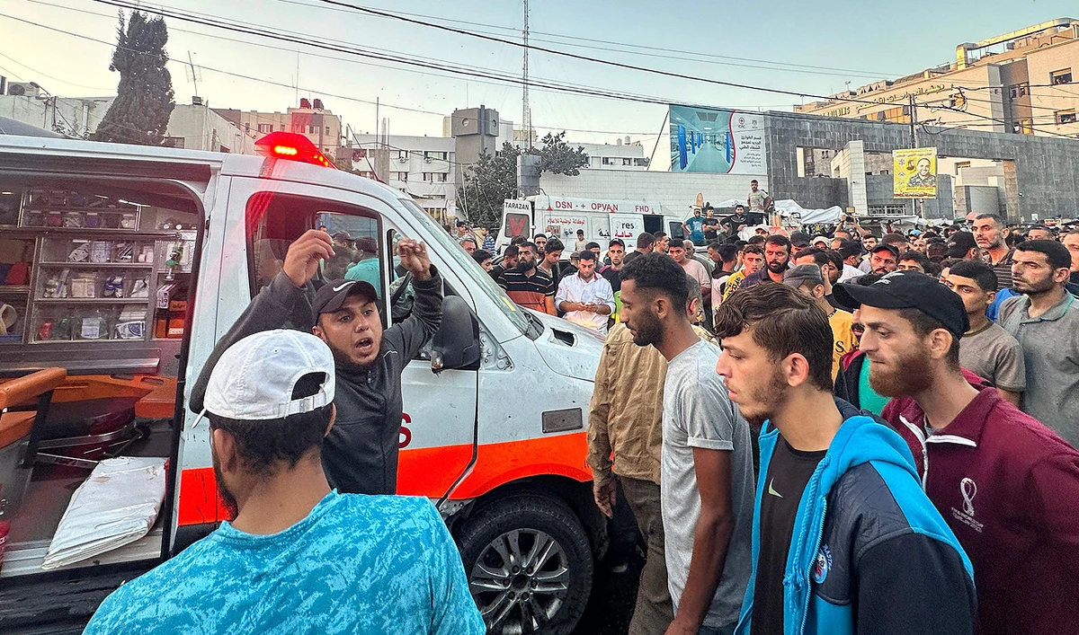 People gather around an ambulance damaged in a reported Israeli strike in front of Al-Shifa hospital in Gaza City on November 3, 2023. (AFP)