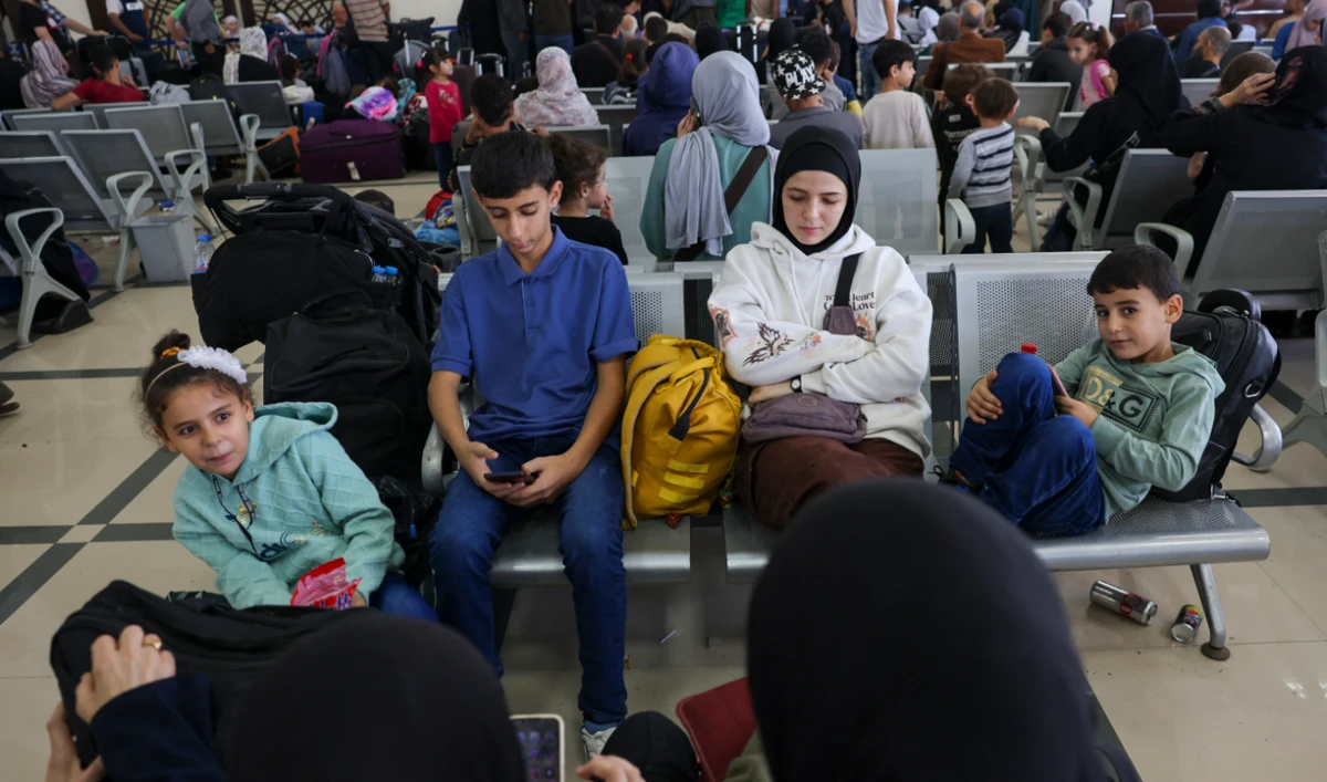 Palestinian dual nationals and foreigners wait to cross the Rafah border crossing with Egypt, in the southern Gaza Strip, on November 7, 2023. (AFP)