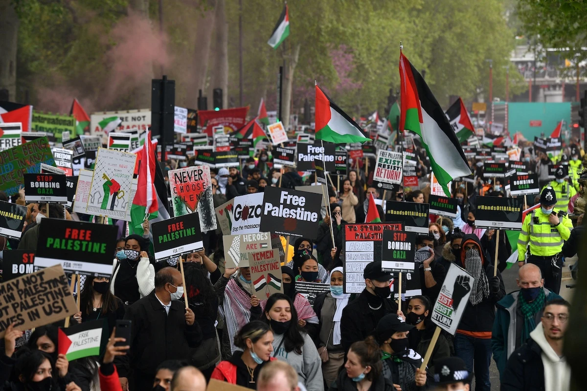 Pro-Palestine demonstrators hold placards as the march to Parliament Square in central London on May 22, 2021. (File/AFP)