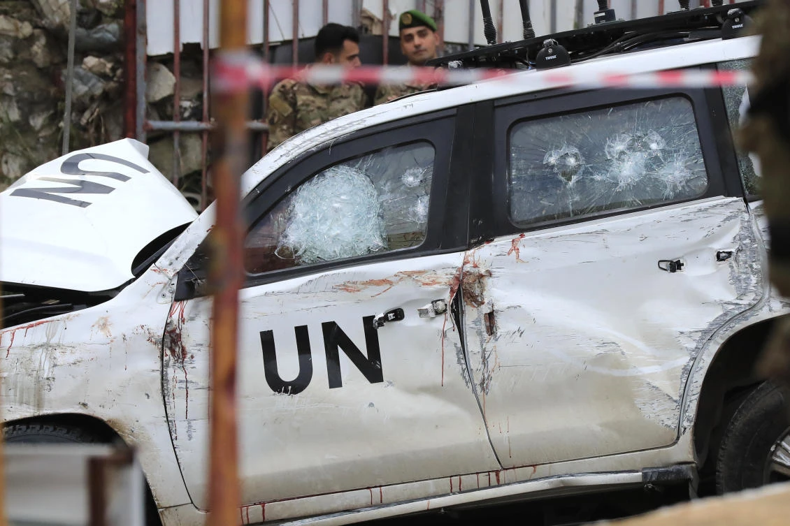 Lebanese soldiers stand behind a damaged vehicle after a UN peacekeepers convoy came under fire in the Al-Aqbiya village, south Lebanon, on Dec. 15, 2022. (AP/File)