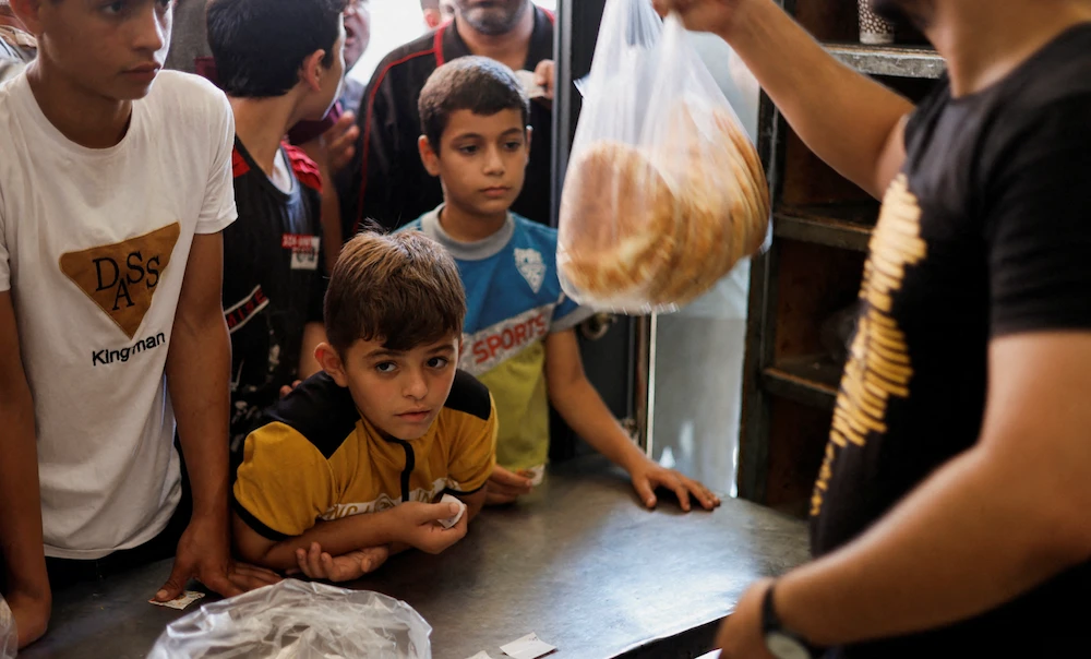 Palestinians wait to buy bread outside a bakery, amid the ongoing conflict between Israel and Palestinian Islamist group Hamas, in Khan Younis in the southern Gaza Strip October 14, 2023. (REUTERS/File)