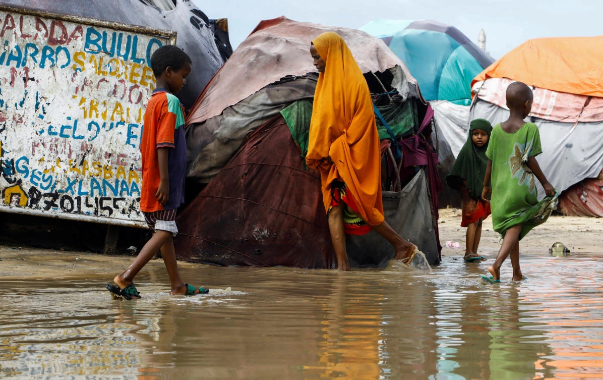 Residents wade through flood waters within their makeshift shelters at the Al-Hidaya camp for the internally displaced people following heavy rains in the outskirts of Mogadishu (REUTERS)