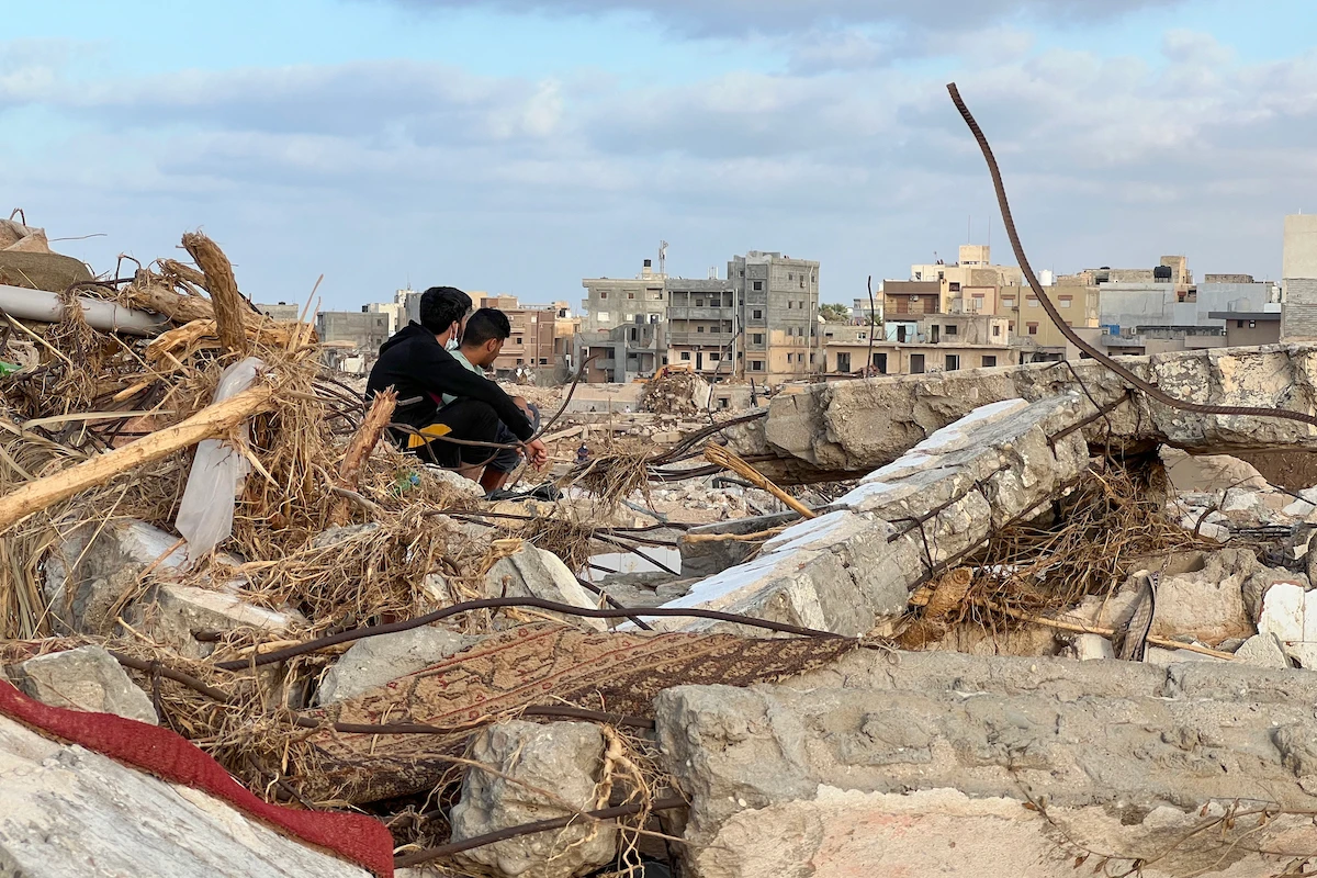 People sit among the rubble in Libya's eastern city of Derna on September 20, 2023, following a deadly flash flood. (File/AFP)