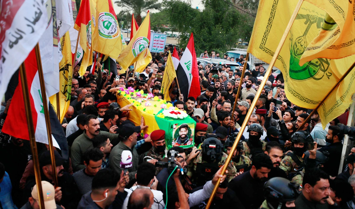 Mourners carry the coffin of Fadel Al-Maksusi, a member of the Hezbollah Brigades, killed during a drone strike, in Baghdad on Tuesday. (AFP)