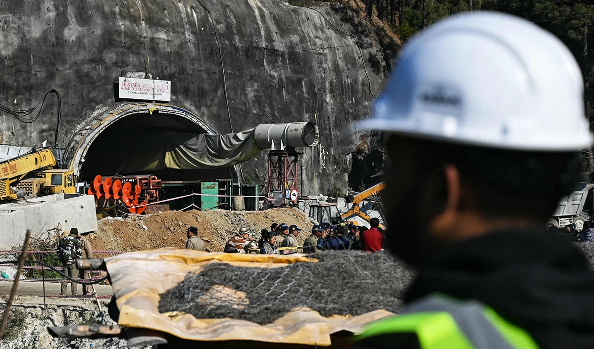 A rescue personnel stands near an entrance of the Silkyara under construction road tunnel, during the final phase of a rescue operation, days after a portion of it collapsed in the Uttarkashi district of India's Uttarakhand state on November 23, 2023. (AFP)