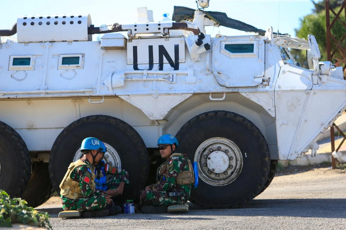 Members of the United Nations Interim Forces in Lebanon (UNIFIL) rest next to an armed vehicle near the southern Lebanese village of Markaba on Nov. 24, 2023. (AFP)