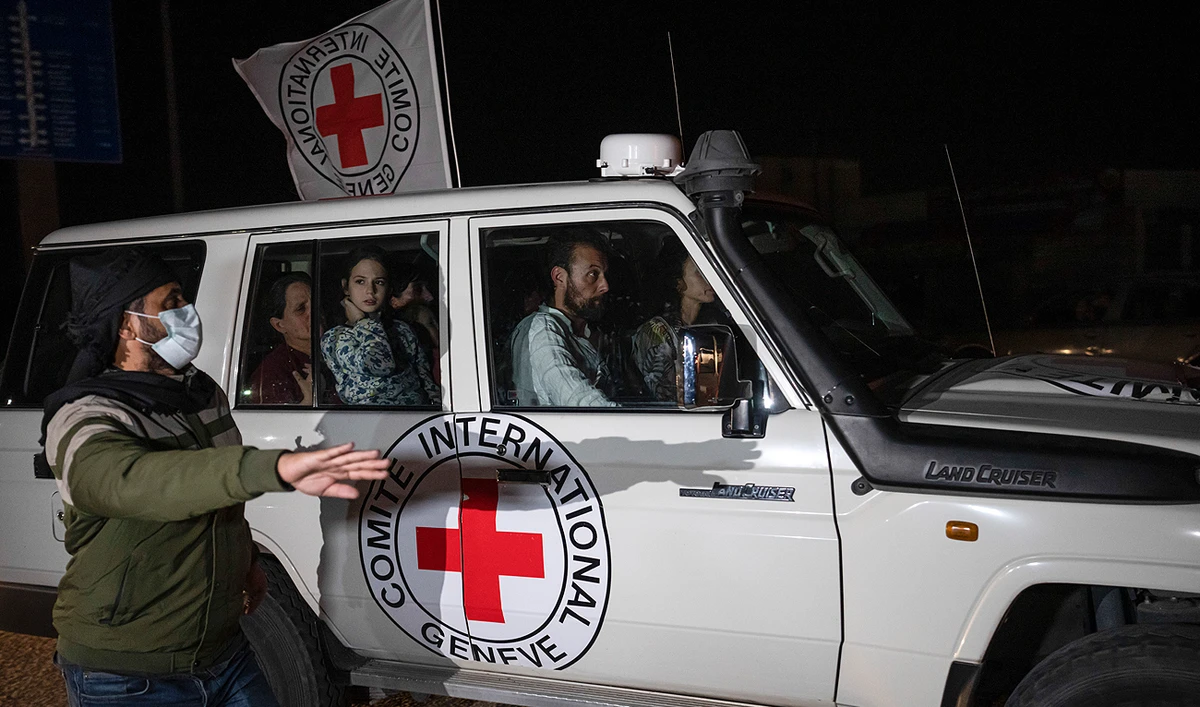 A Red Cross vehicle carrying Israeli hostages drives by at the Gaza Strip crossing into Egypt in Rafah on Saturday, Nov. 25, 2023. (AP)