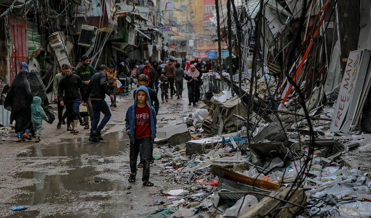 Palestinians walk amid debris of buildings hit in Israeli strikes, near Al-Zawiya market in Gaza City on November 27, 2023, on the fourth day of a truce in fighting between Israel and Hamas. (AFP)
