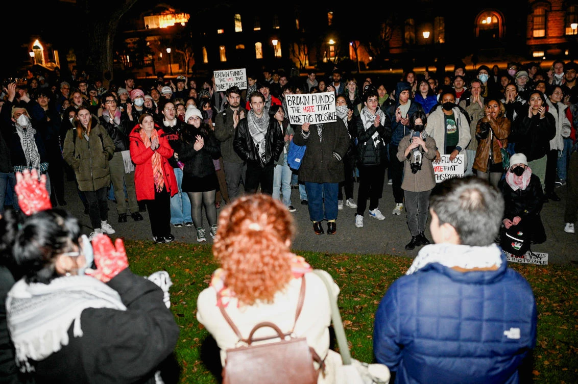 People hold up signs and protest following a vigil held on the grounds of Brown University, after three students of Palestinian descent were shot and wounded in Vermont, at the school's main green in Providence, Rhode Island on Nov. 27, 2023. (Reuters)