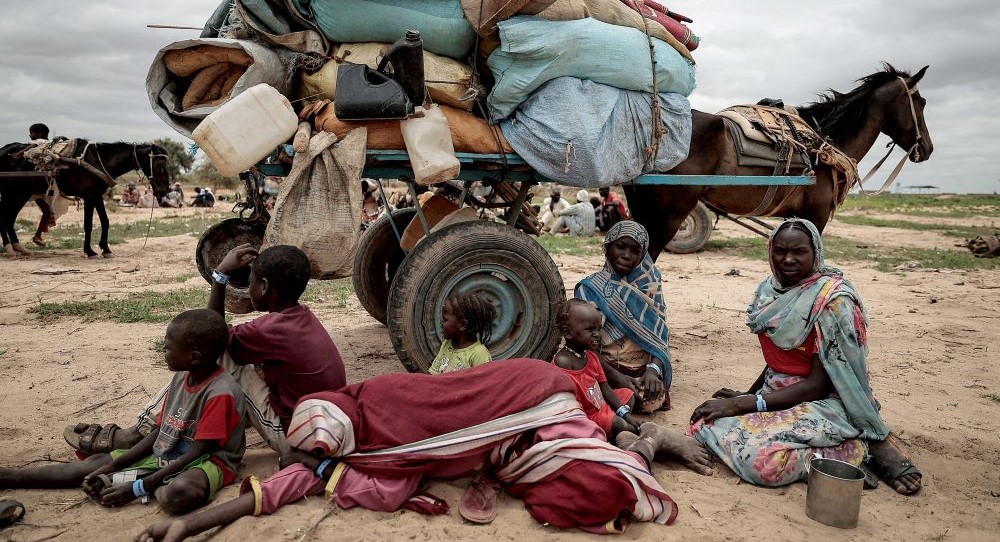 A family, who fled the conflict in Murnei, Darfur, sits beside their belongings, Adre, Chad, July 26, 2023. (Reuters)
