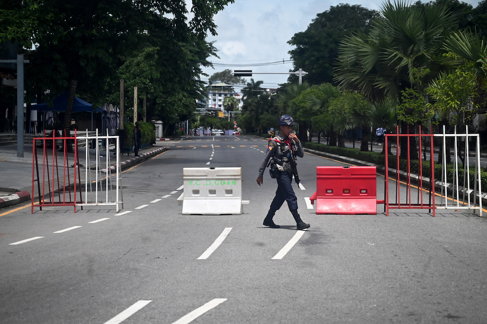 Above, a member of the Myanmar security forces mans a checkpoint in Yangon on July 19, 2022. (AFP)