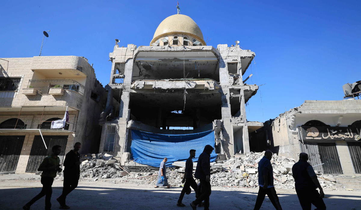 Palestinians walk past the rubble of the al-Saqa Mosque, damaged during an Israeli strike, at Khan Yunis in the southern Gaza Strip on November 16, 2023, amid continuing battles between Israel and the militant group Hamas. (AFP)